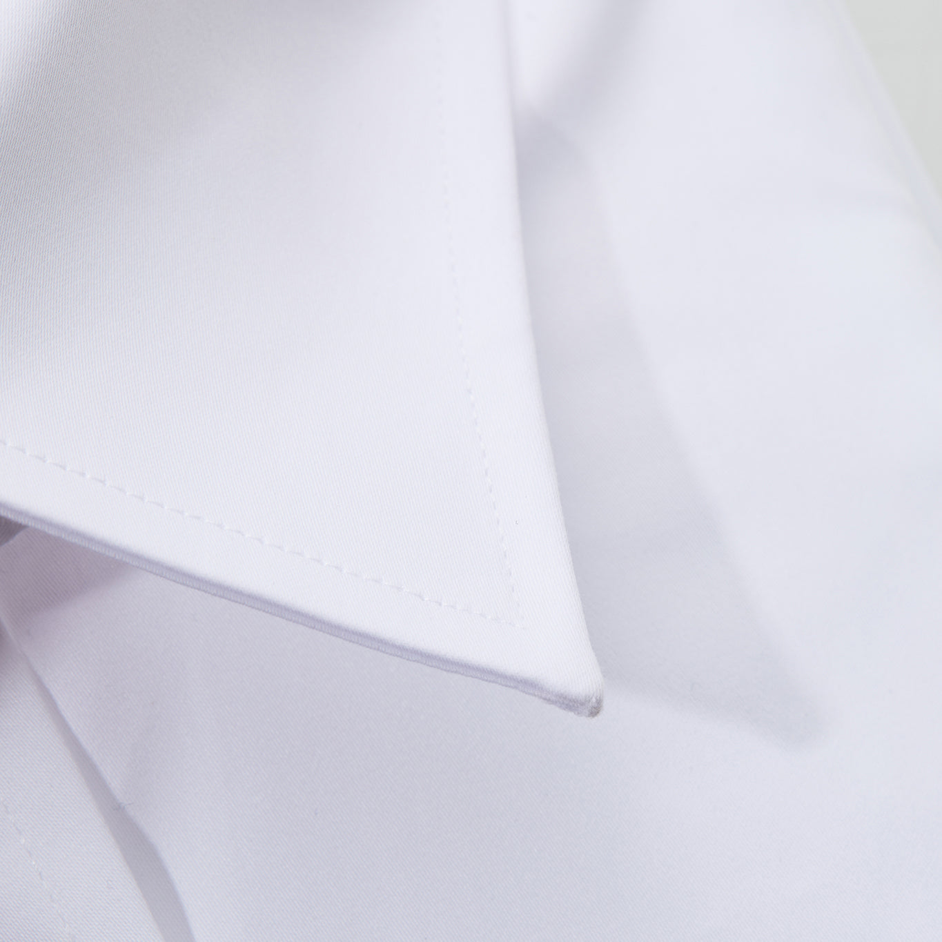Close-up of a collar tip on a white shirt